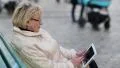Woman sits on the bench and uses tablet computer HD Footage