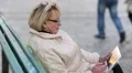 Woman sits on the bench and uses tablet computer HD Footage