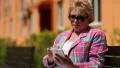 Woman sits on the bench in courtyard and uses white smartphone HD Footage