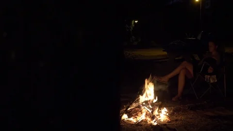Woman Sits in Chair While Talking in Front of Fire Stock Footage