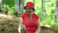 Woman sits on a fallen tree in the forest and communicates via smartphone HD Footage