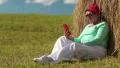 Woman sits on a green grass and communicates via cell phone HD Footage