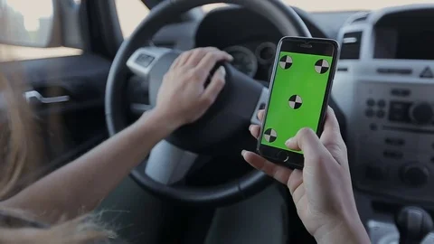 Woman sits in the modern car and works on smartphone - closeup hands. Stock Footage