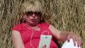 Woman sits near haystack and communicates via smartphone HD Footage