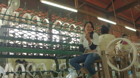 A woman sits next to silk thread production equipment Stock Footage 48012121