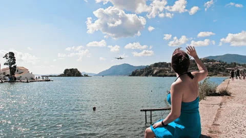 Woman Sits, Pier Corfu Airport Plane Spotting Spot Admires The Weather Stock Footage
