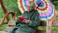 Woman sits on the swing bench and uses red smartphone HD Footage