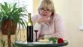 Woman sits at a table and looking into camera HD Footage