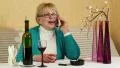 Woman sits at the table and speaks on the smartphone HD Footage