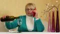 Woman sits at the table, drinks red wine and speaks on smartphone HD Footage