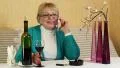 Woman sits at the table, drinks red wine and talks on smartphone HD Footage