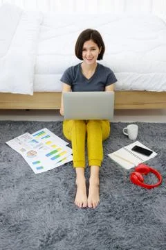 Woman sitting and using computer in bedroom Stock Photos