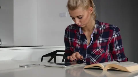 Woman sitting and using mobile and tablet pc. Book is on the table. Stock Footage 62019104