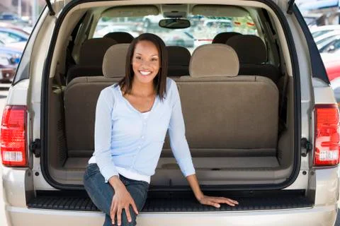 Woman sitting in back of van smiling Stock Photos