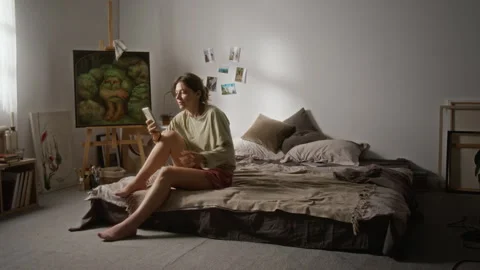 Woman Sitting on Bed Using Smartphone at Home Stock Footage 345215508