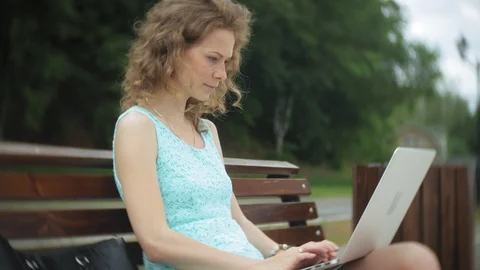 A woman sitting on a bench on the beach using a laptop Video stock 93197499
