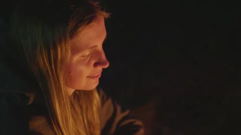 The woman sitting by the bonfire and looking at fire late in the evening. Stock Footage 277707860