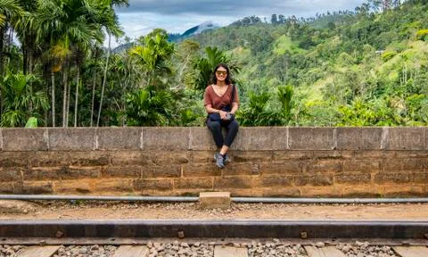 Woman sitting on brick wall, railway viaduct, Ella, Sri Lanka Stock Photos