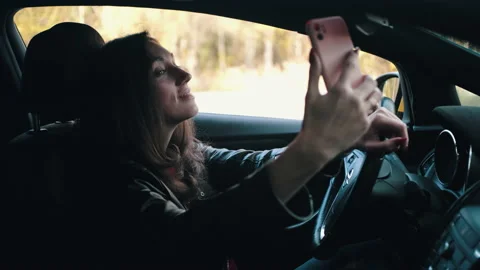 Woman is sitting in the car and using phone's camera Stock Footage