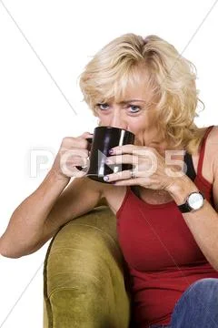 Woman sitting on a chair drinking coffee Stock Photos
