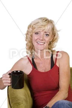 Woman sitting on a chair drinking coffee Stock Photos