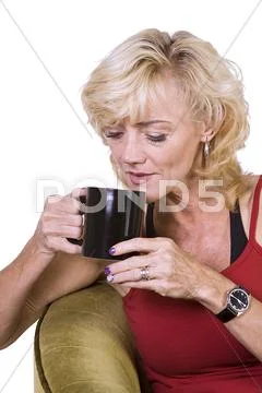Woman sitting on a chair drinking coffee Stock Photos