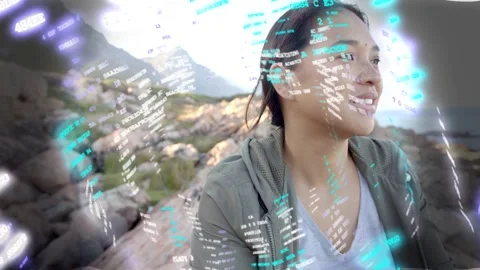 Woman sitting on coast, sequence advancing AR code overlay around her turning Stock Footage 333689884