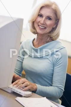 Woman sitting at computer typing (high key) Stock Photos