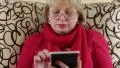 Woman sitting on a couch and using electronic book. Woman with e-book HD Footage