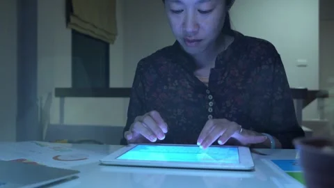 A woman is sitting at a desk and using a tablet Video stock 318914714