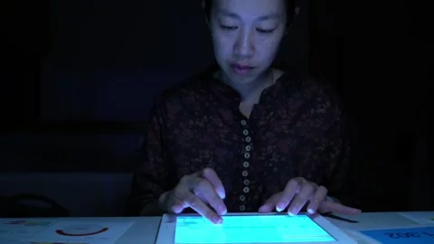 A woman is sitting at a desk and using a tablet Video stock 318914726