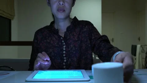 A woman is sitting at a desk and using a tablet Video stock 318914760