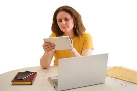 Woman sitting at desk using tablet and laptop. Freelancer working on digital  Stock Photos