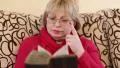 Woman sitting on a divan and reading old book HD Footage