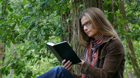 A woman sitting on a fallen tree Video stock 54574192