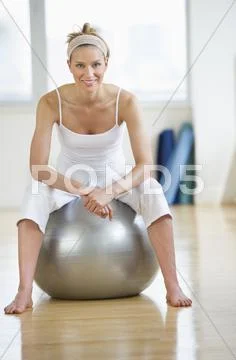 Woman sitting on fitness ball Stock Photos