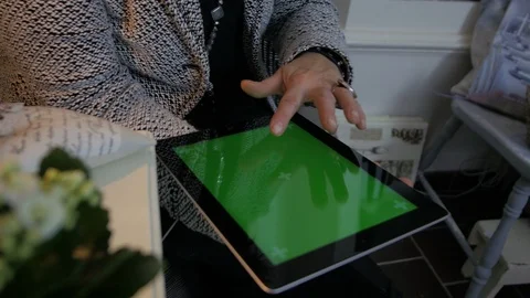Woman sitting on the floor and using vertical tablet computer with green screen Stock Footage 88564487