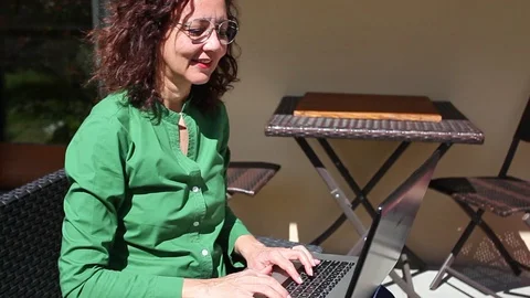 Woman sitting in the garden while using her laptop Stock Footage 129570294
