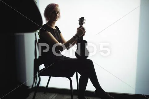 Woman Sitting With A Guitar In Music School
