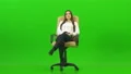 The woman sitting on the office chair on the green background 4k or 4k+ Resolution