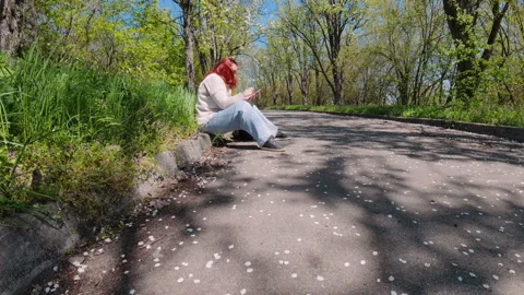 Woman Sitting On Park Path Using Smartphone In Spring 스톡 동영상 336376852