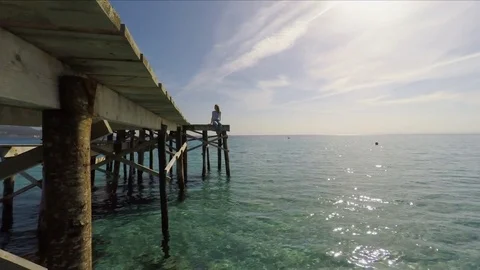Woman sitting on pier Stock Footage