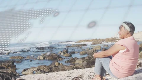 Woman sitting shore, code overlay drifting partly obscuring her then revealing Stock Footage 332705066