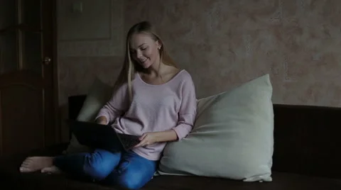 Woman sitting at sofa and using laptop Stock Footage 65468861