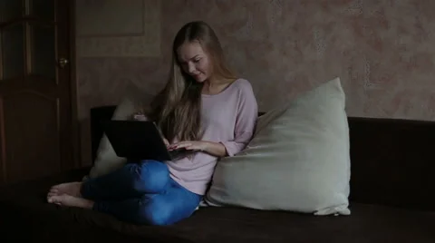 Woman sitting at sofa and using laptop Stock Footage 65470695