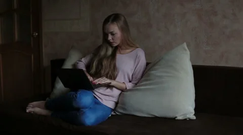 Woman sitting at sofa and using laptop Stock Footage 65471103