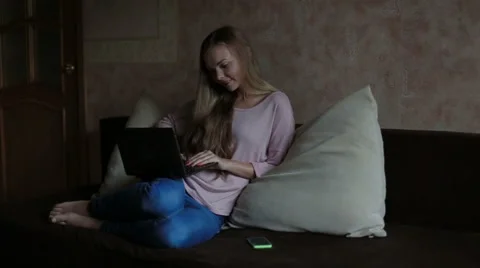 Woman sitting at sofa and using laptop Stock Footage 65471410