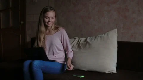 Woman sitting at sofa and using laptop Stock Footage 65472627
