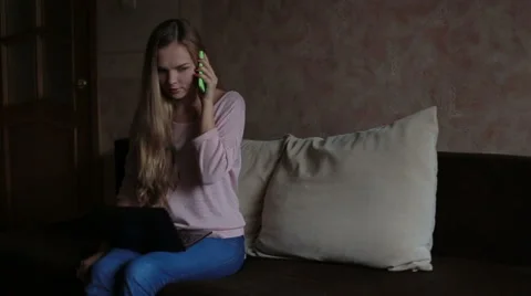 Woman sitting at sofa and using laptop Stock Footage 65473408