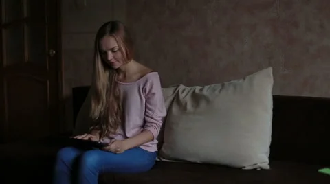 Woman sitting at sofa and using laptop Stock Footage 65473883